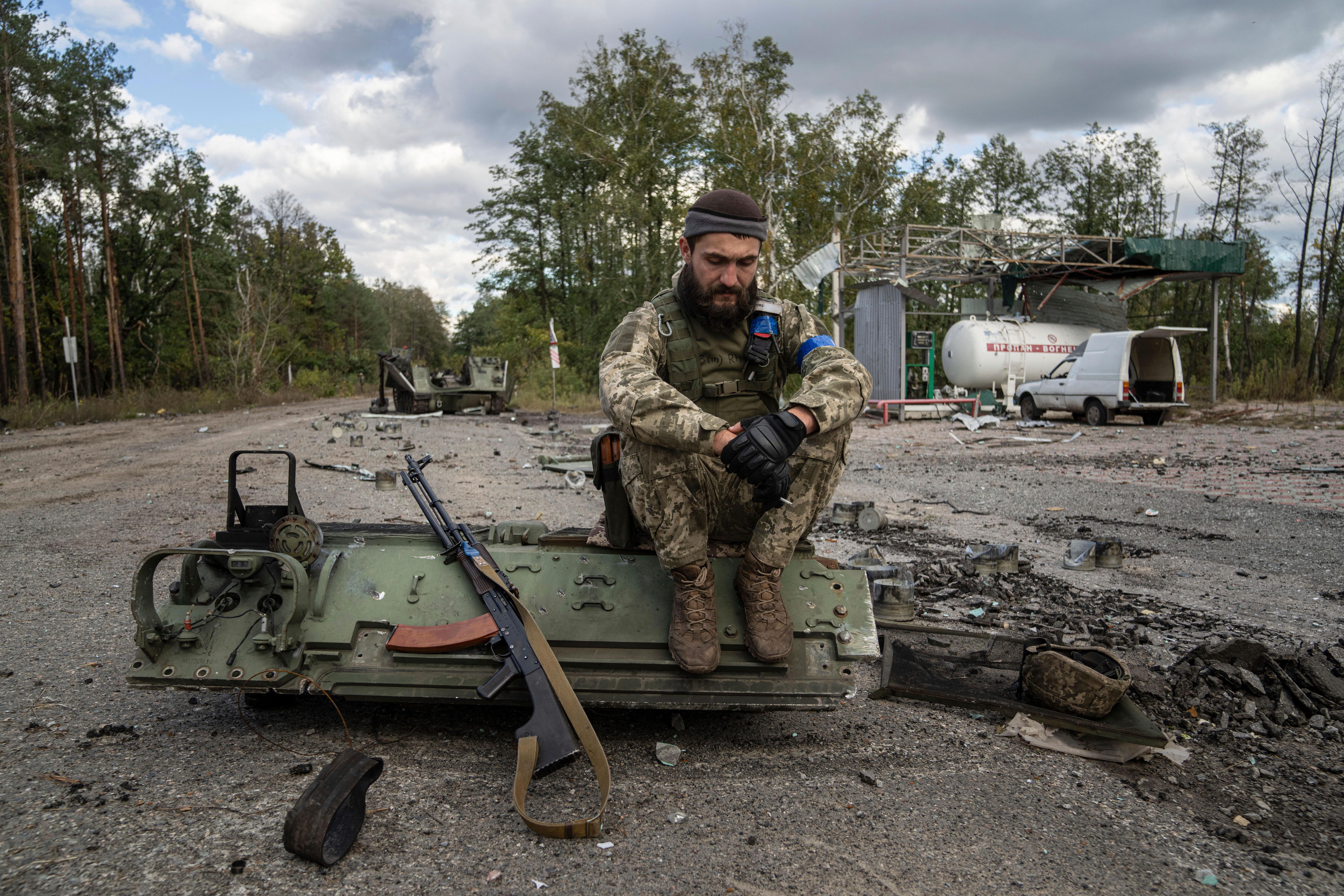 一名乌克兰军人在找到并识别了同志的尸体后抽烟。